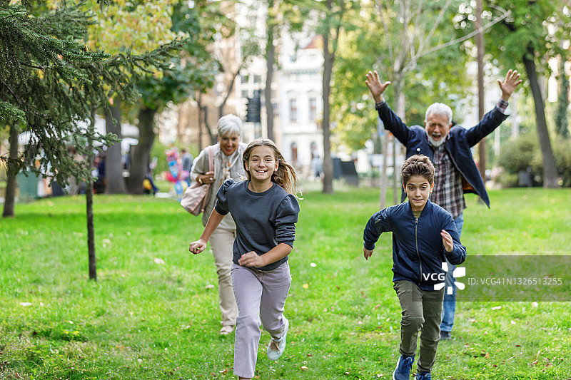 祖父母和孙子孙女在公园里散步图片素材