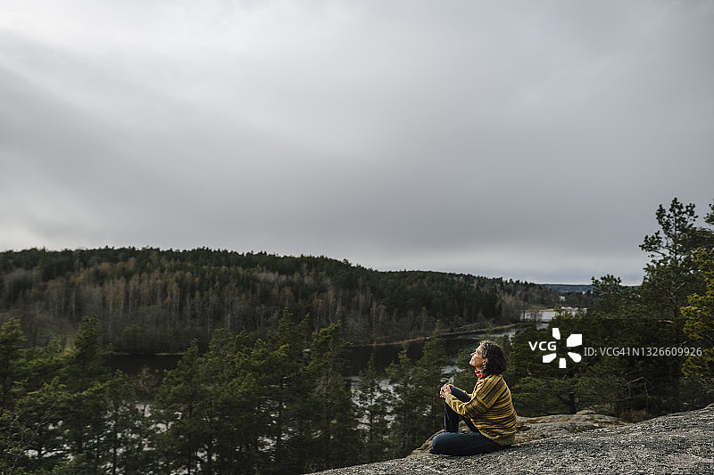中年妇女探险家坐在山上图片素材