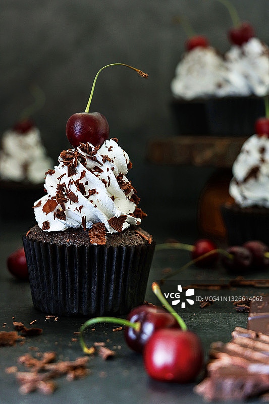 黑森林蛋糕纸杯蛋糕图片：自制，纸质蛋糕盒，木制蛋糕架，鲜奶油玫瑰花结，莫雷洛樱桃和巧克力屑图片素材