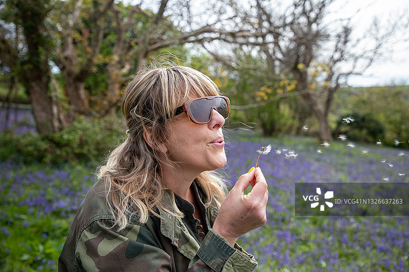 女士吹蒲公英图片素材