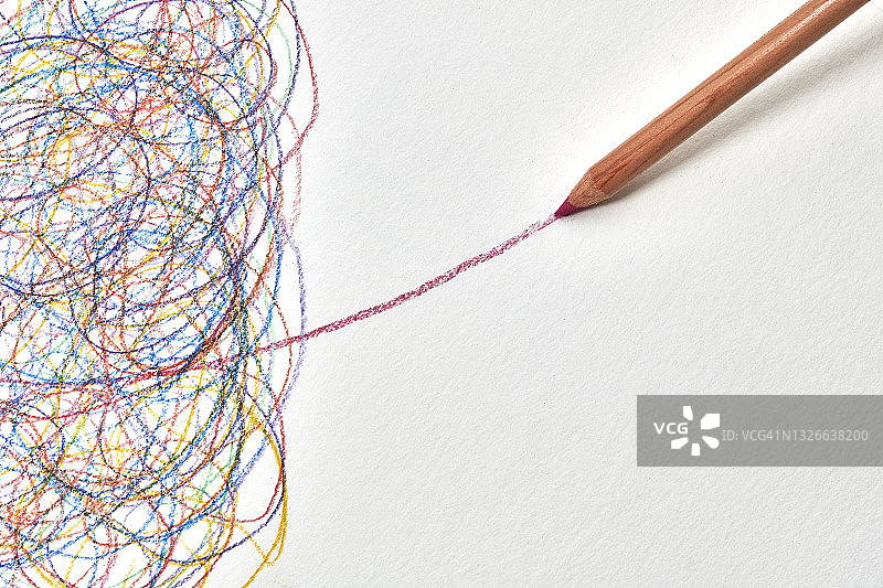 一支红色铅笔在白色背景上混乱的笔迹中画出一条线图片素材