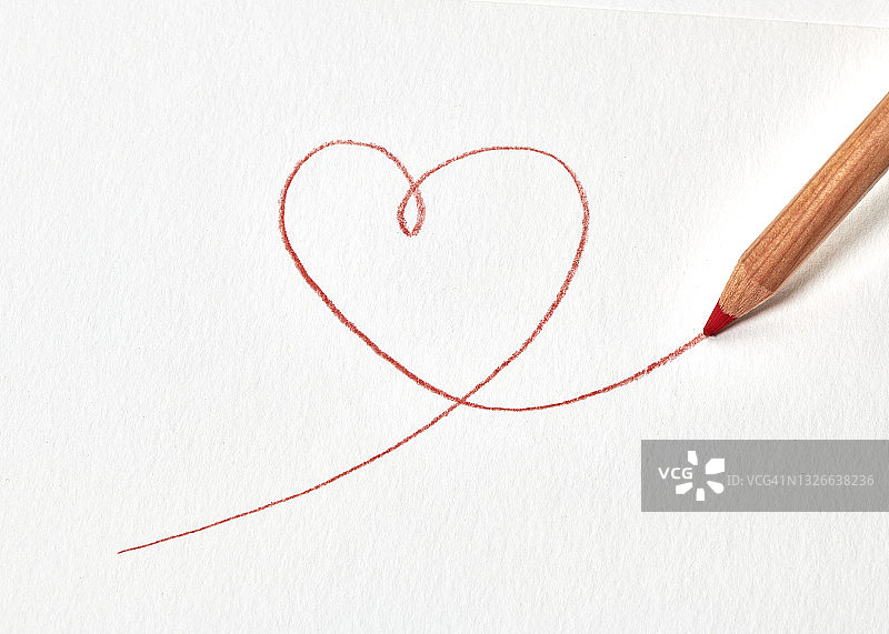 一支红色铅笔在白色纸上画一个心形图片素材