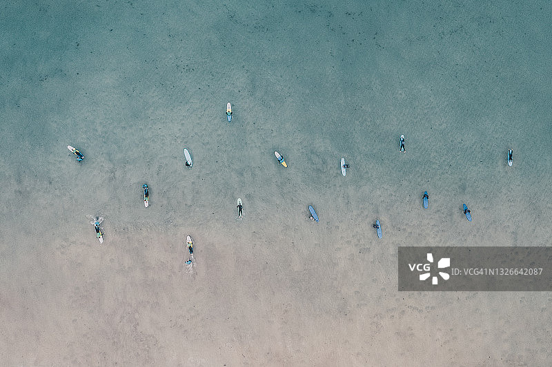 一群冲浪者在Fistral海滩外等待海浪，从纽奎尔正上方看，康沃尔，英国图片素材