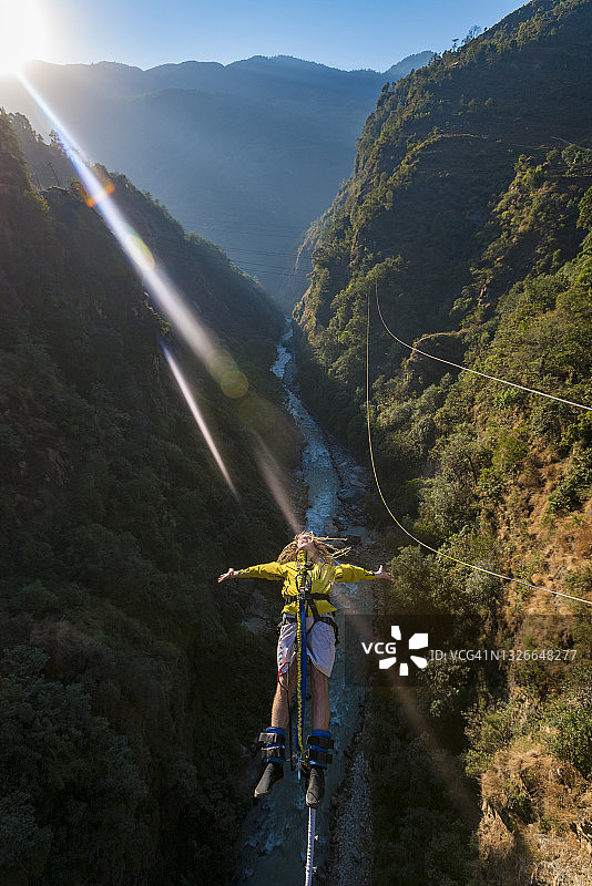 男人在尼泊尔博特科西河的桥上玩峡谷秋千图片素材