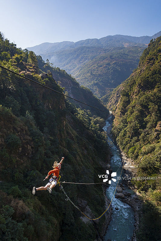 男人在尼泊尔博特科西河的桥上玩峡谷秋千图片素材
