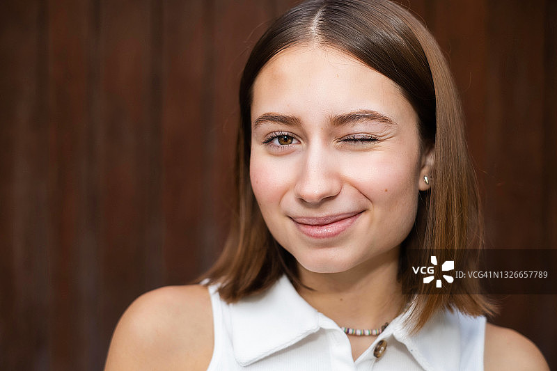 对着镜头微笑眨眼的年轻拉丁裔女性图片素材