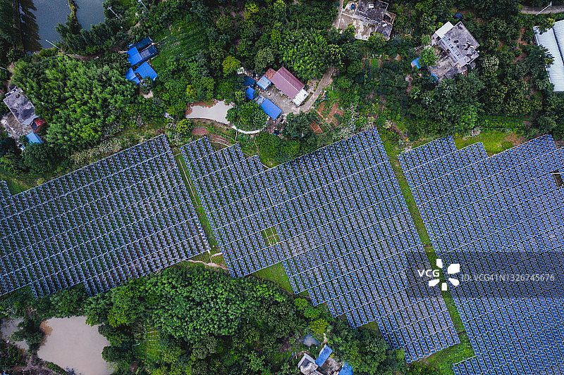 中国乡村地区大型太阳能发电厂鸟瞰图，周围是村庄和稻田图片素材