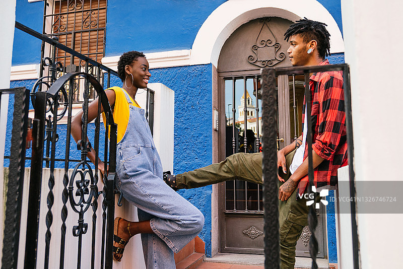 年轻女子靠墙与朋友交谈图片素材