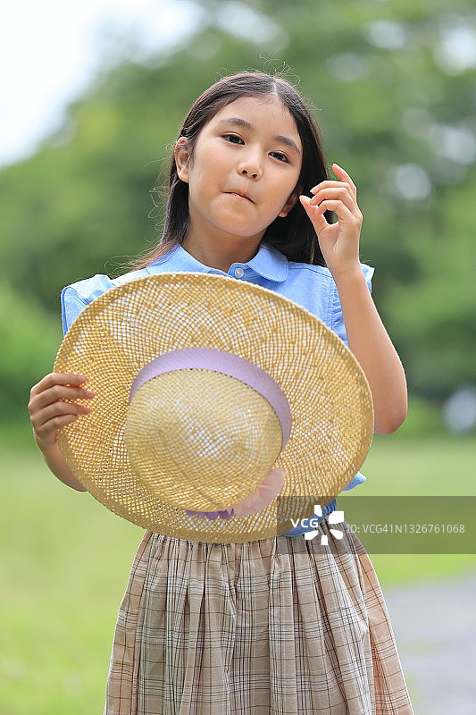 穿着夏装手拿草帽的漂亮女人图片素材