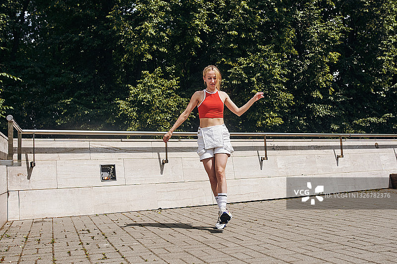 年轻漂亮的苗条女人在城市街道上跳墨尔本曳步舞图片素材