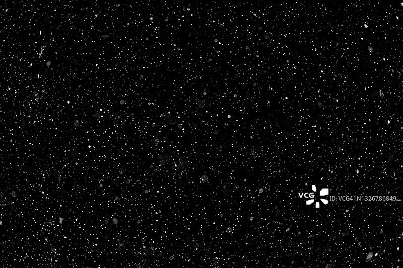 黑色背景上的白色雪花飘落效果图片素材