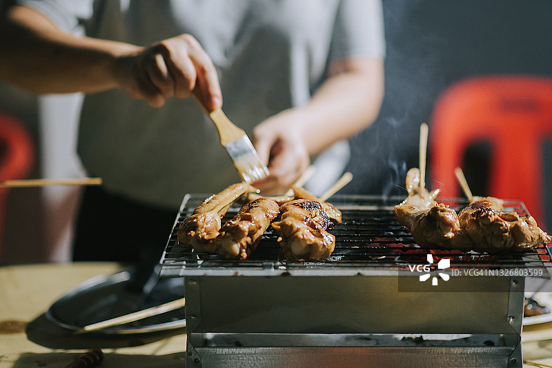 夜晚烧烤派对：准备食物，刷油和蜂蜜图片素材