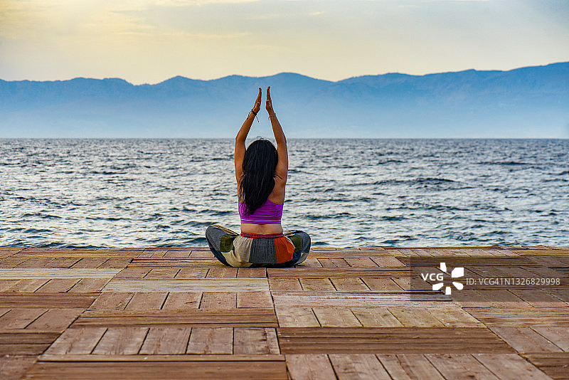 瑜伽老师在木制码头上做瑜伽图片素材
