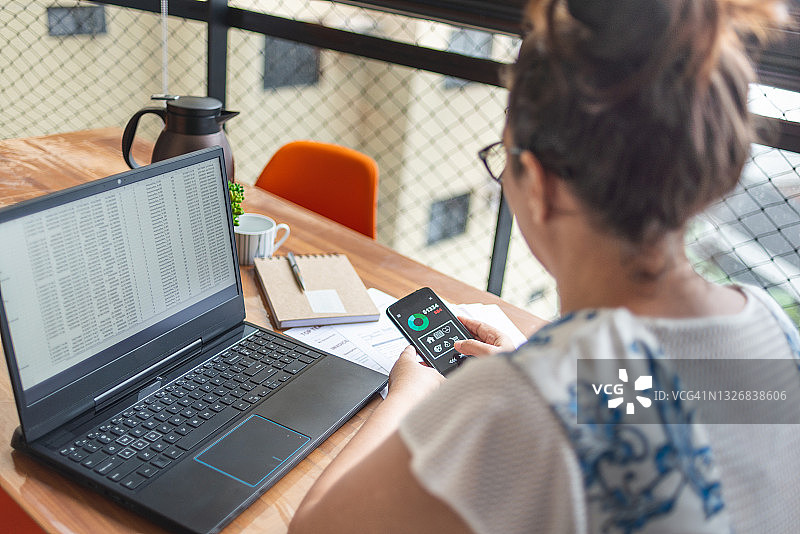 中年妇女使用手机银行App理财图片素材