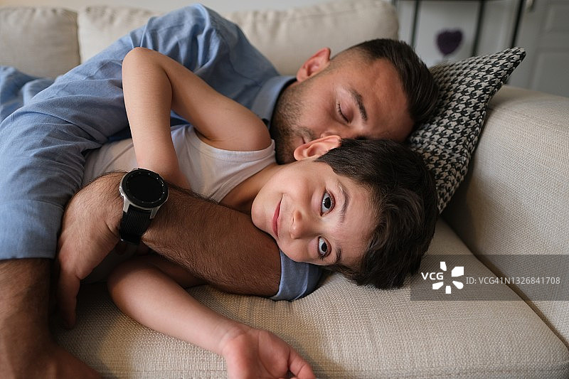 父亲和男孩在沙发上睡觉图片素材