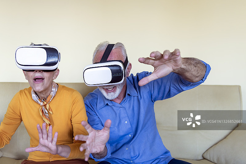 一对退休人员比划着笑着玩VR游戏图片素材