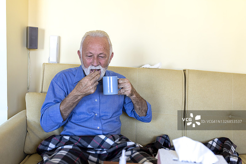 患有高烧和流感的生病老人正在服用热饮药物图片素材