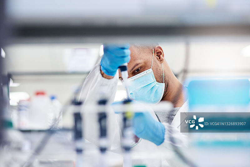 年轻男实验技术员将样本注入试管的照片图片素材