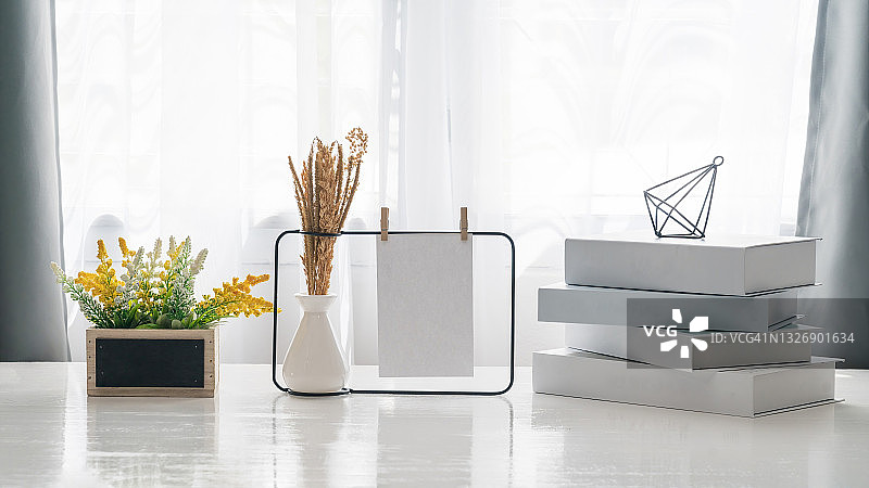 带垂直框架和花瓶植物的室内海报样机，白色墙壁背景。客厅的室内设计，白色架子上带有白色样机相框和盆栽植物图片素材