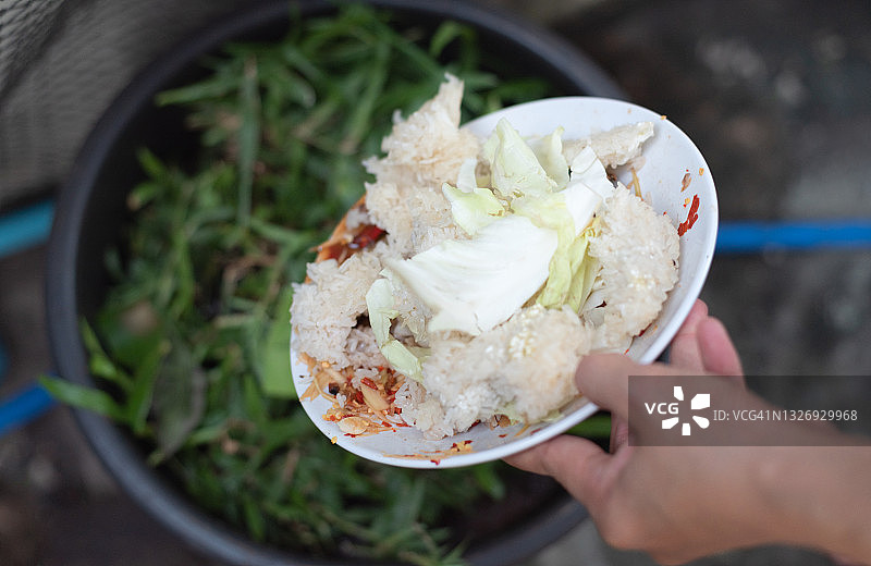 蔬菜皮从砧板扔进装有有机食物垃圾的铁碗中图片素材