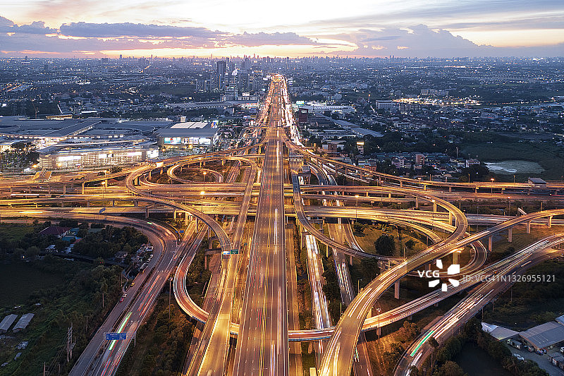 黄昏时分多车道高速公路、立交桥、高架道路、道路、道路交叉口的鸟瞰图图片素材