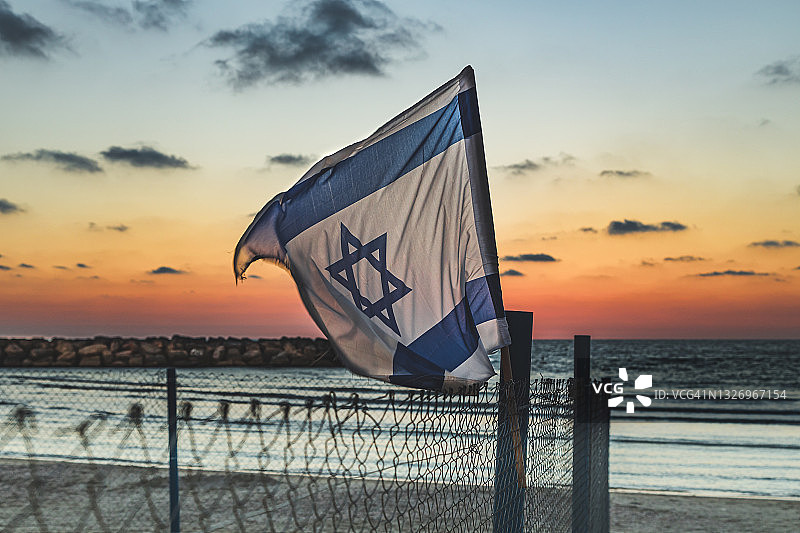 日落时分的地中海边的以色列国旗图片素材