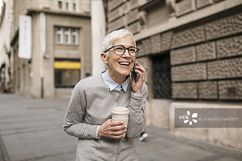 户外使用智能手机的年长的白人妇女图片素材