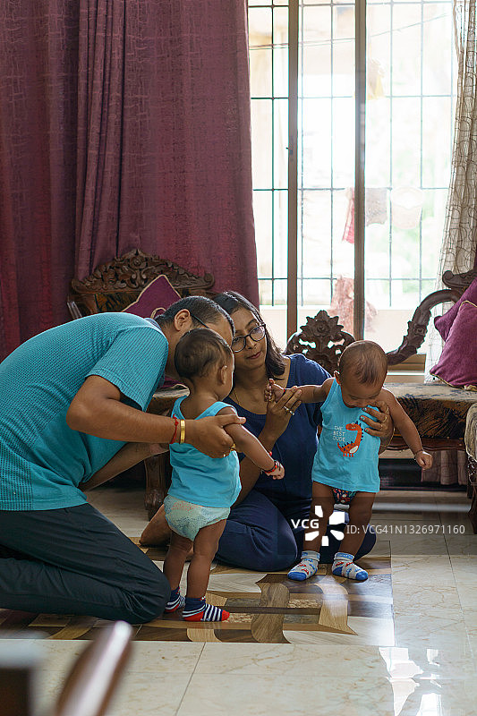 印度父母和他们的年轻双胞胎儿子玩耍图片素材