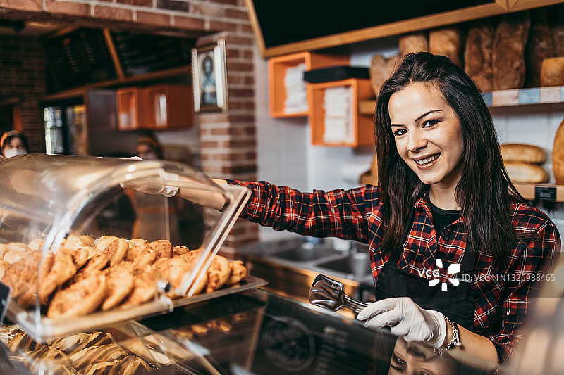 小生意：漂亮的女孩在卖糕点图片素材