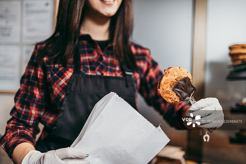 小生意：漂亮的女孩在卖糕点图片素材