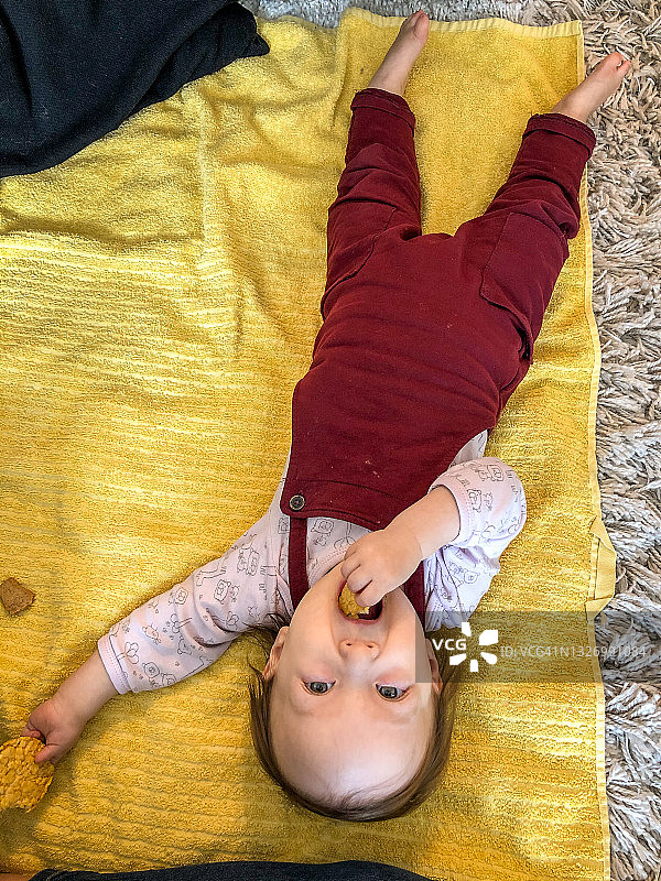 孩子躺着吃零食图片素材