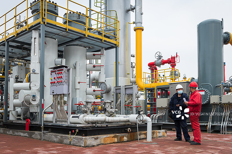 化工厂内工程师与工作人员现场交流图片素材