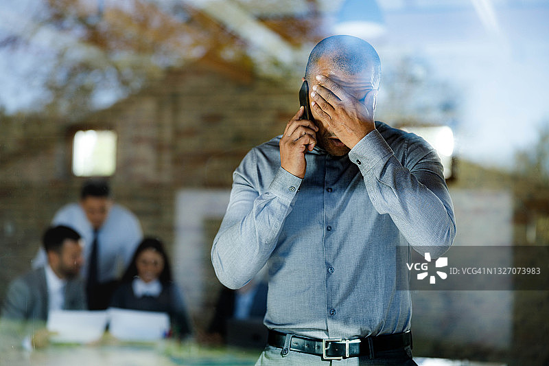 在办公室用手机通话的黑人商人图片素材