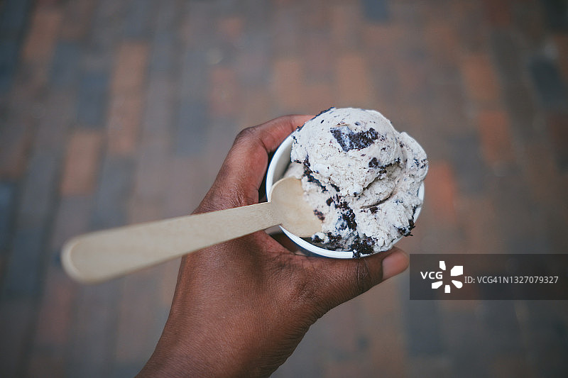 女人手拿曲奇奶油冰淇淋图片素材