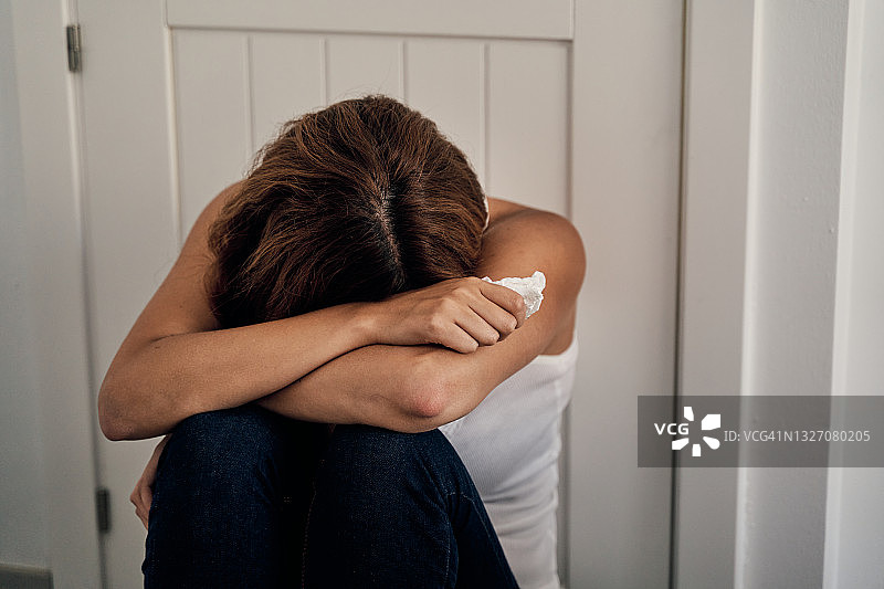 坐在门边哭泣的受虐妇女图片素材