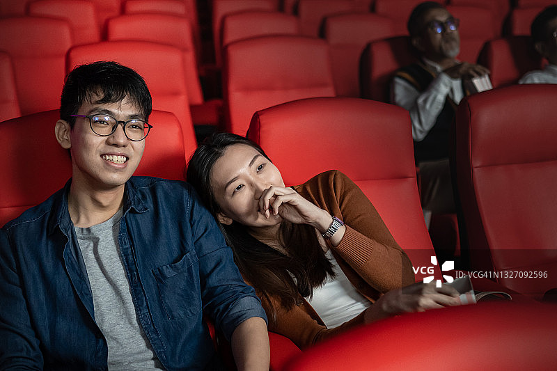 亚洲中国情侣电影院吃爆米花看电影图片素材