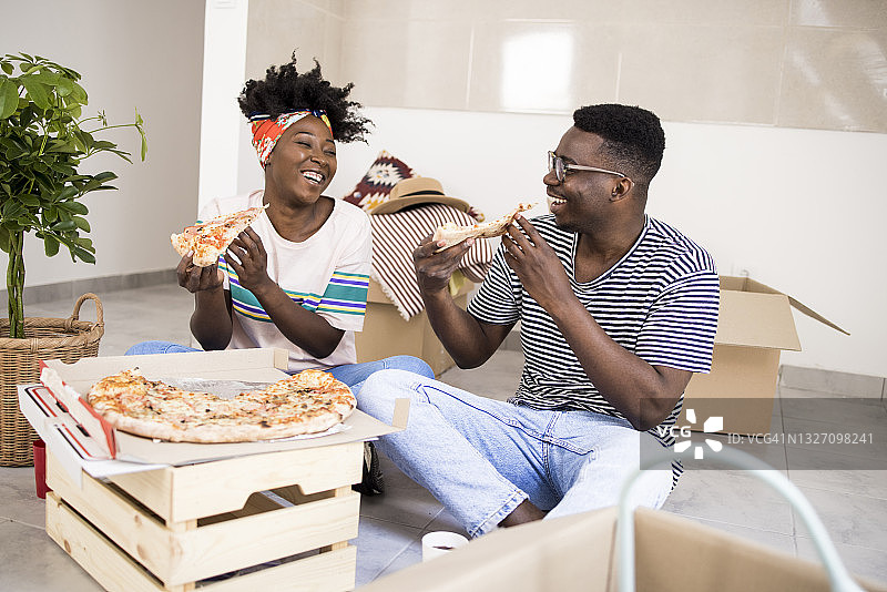 搬新家时吃披萨休息的快乐情侣图片素材