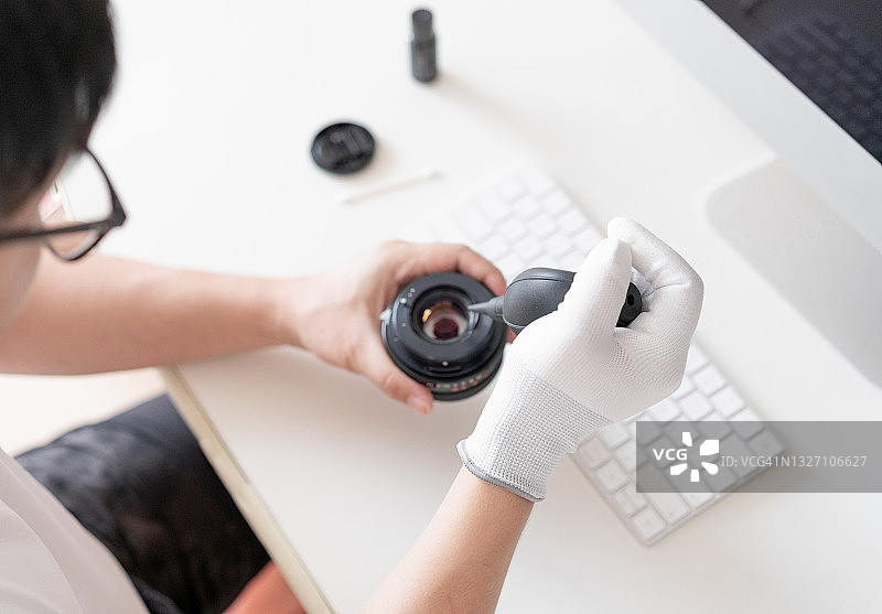 男人清洁和修理胶片相机图片素材