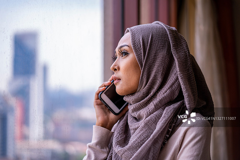 使用手机的马来穆斯林年轻女子图片素材