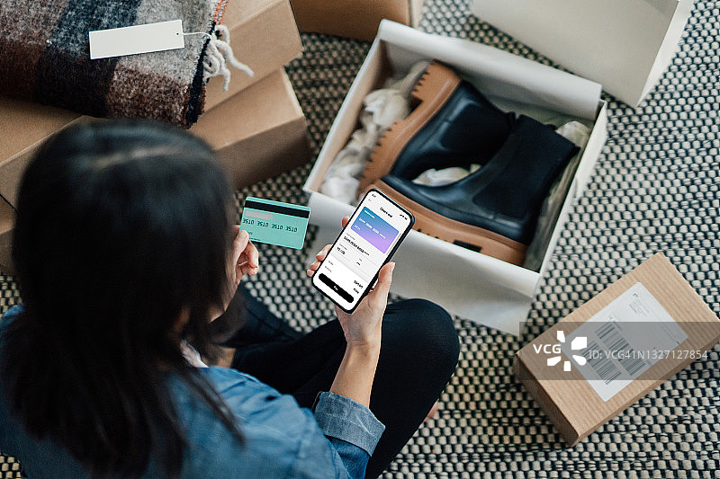 年轻女子用智能手机在线购物的俯视图图片素材
