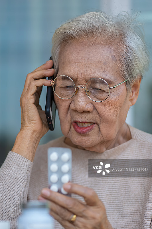 在家用手机和医生交谈的年长女病人图片素材