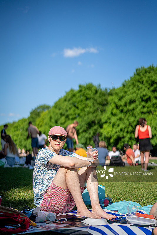 年轻男人在公园里享受野餐图片素材
