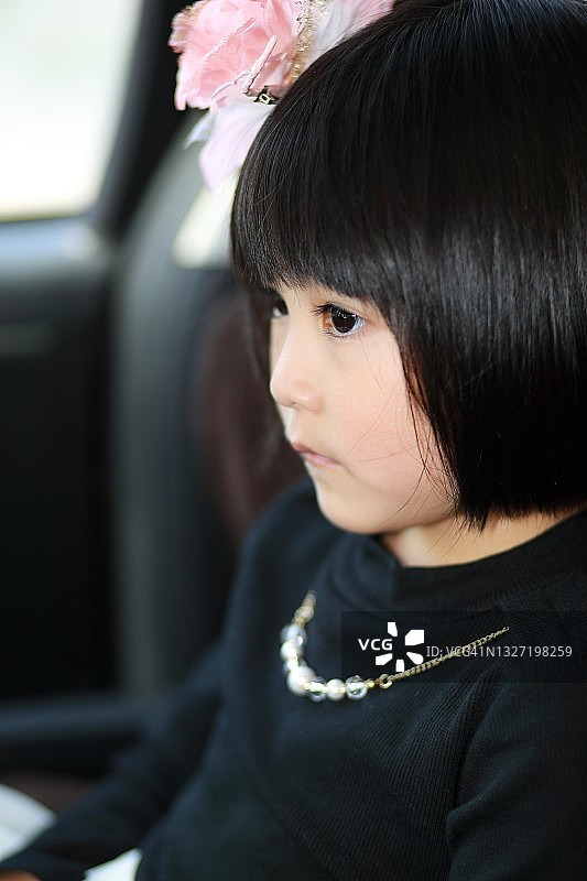 戴着项链和发饰，穿着黑色长袖的专注女孩图片素材