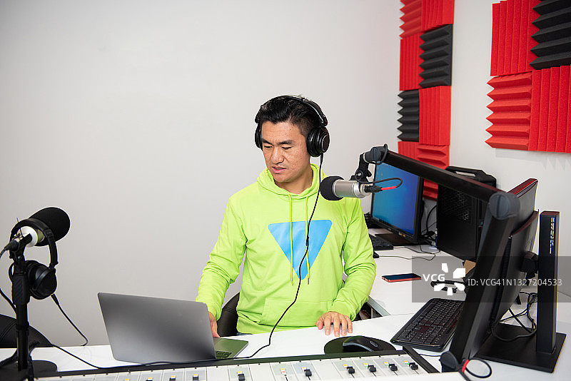 年轻的亚洲男性主持人在广播电台工作图片素材