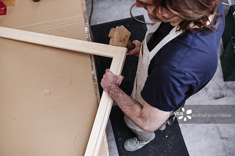 工匠在车间用锤子制作木框图片素材