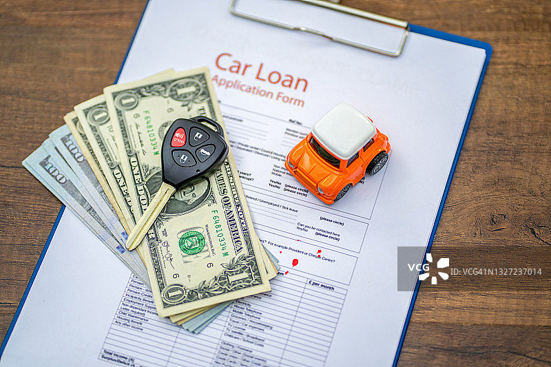 汽车保险概念：汽车模型、美元与保单图片素材