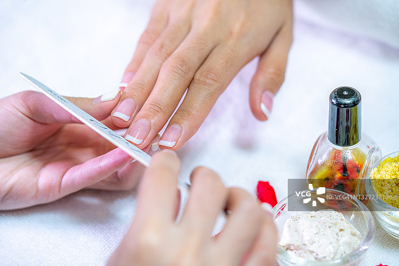 美甲师用指甲锉为顾客做美甲的特写镜头图片素材
