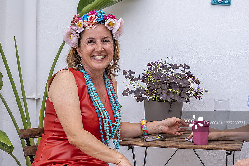 一位头上戴着鲜花的快乐女士正在看着镜头。图片素材