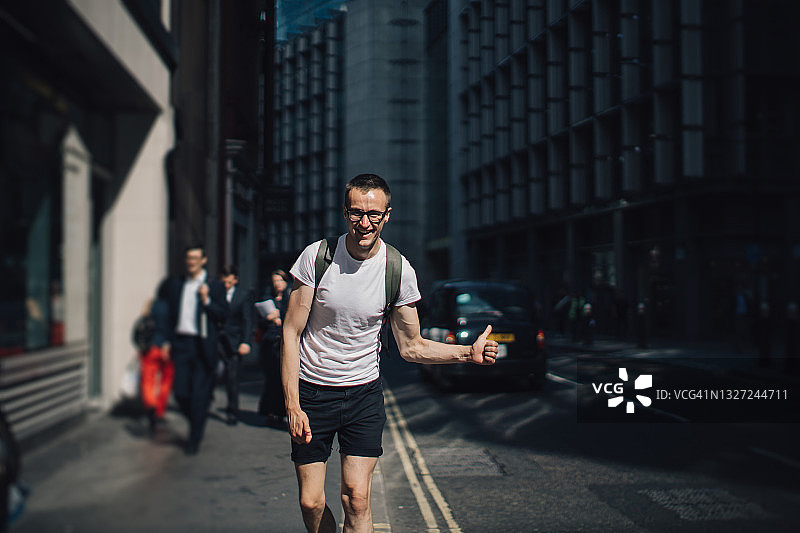 在城市道路上搭便车的男人图片素材