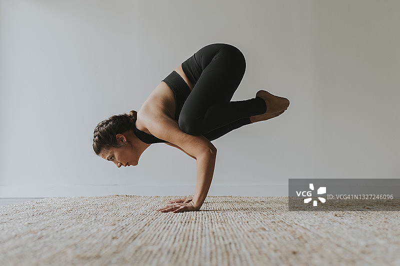 瑜伽修行者在健身俱乐部练习乌鸦式图片素材